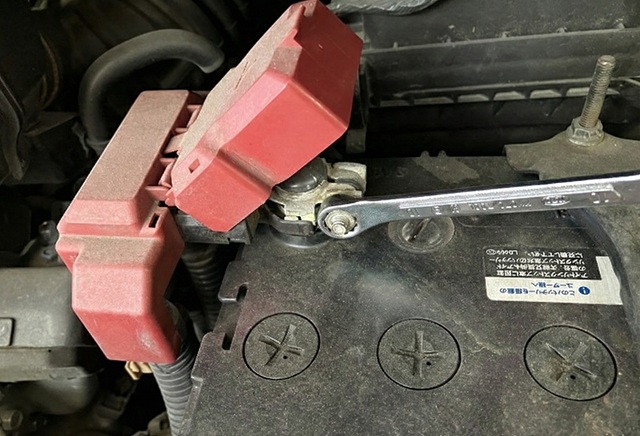 コンビネーションレンチでプラス端子を外す